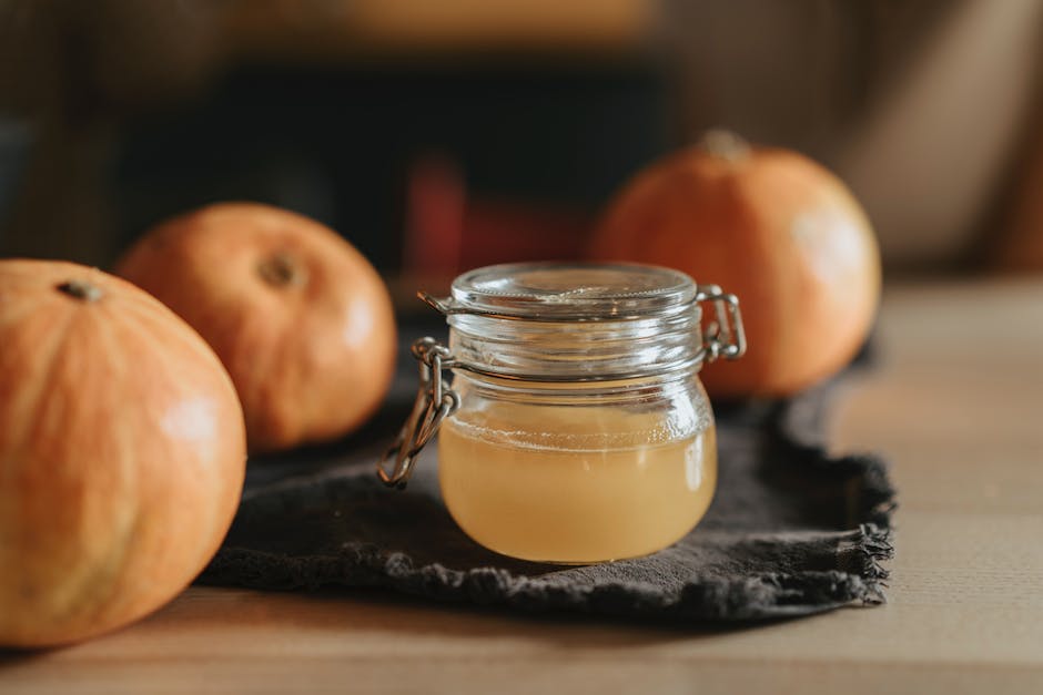 A person producing apple cider vinegar at home, demonstrating the prevention and troubleshooting of potential mold issues.