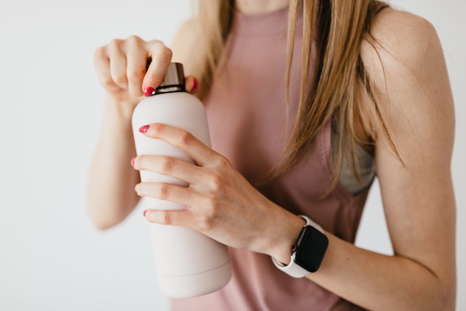 A bottle of apple cider vinegar with a spray bottle, illustrating how to use ACV in hair care.