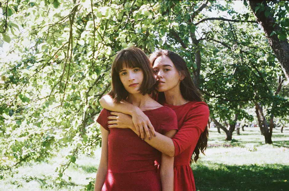 A family standing in an apple orchard, picking apples.