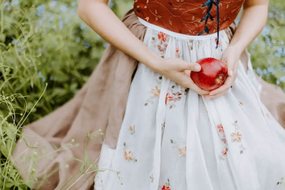 An image of a person holding a red apple in an orchard in Winchester, Virginia