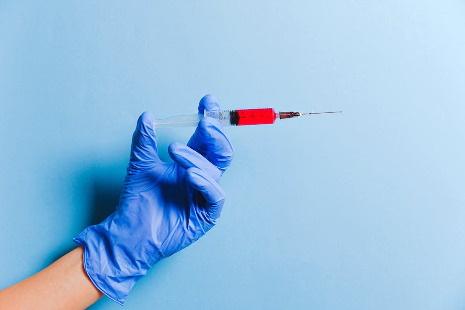 A picture of a doctor taking blood from a patient's arm using a needle.