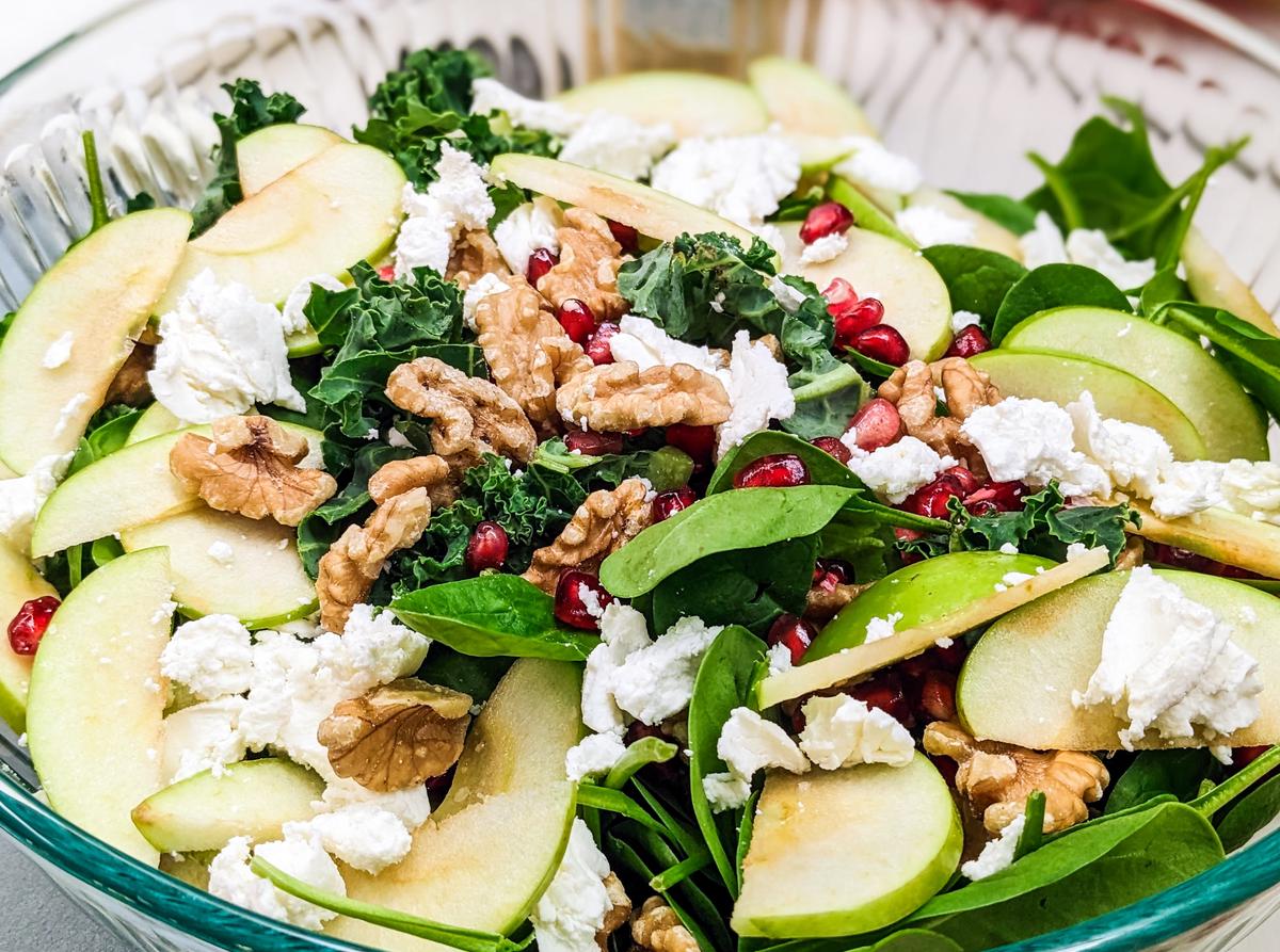 A plate of a Honey Crisp Apple Salad with Candied Walnuts, showing the various ingredients and the finished dish.