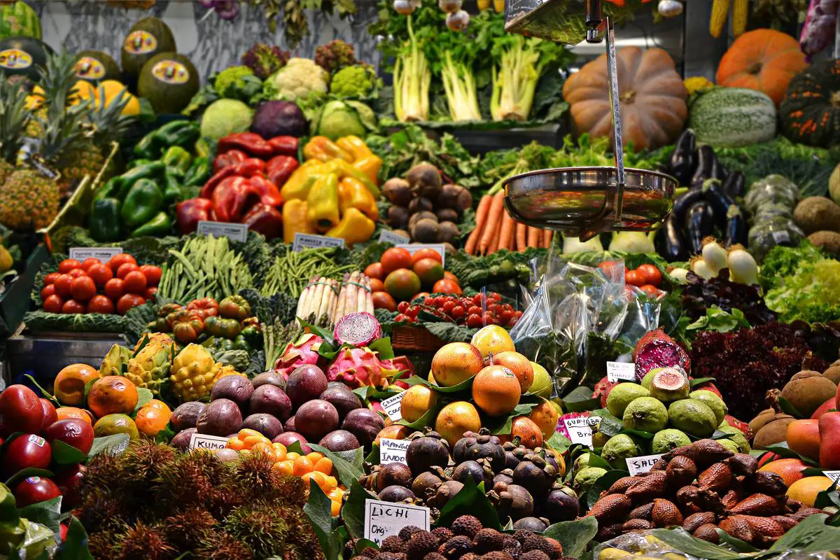 A bustling produce market with colorful fruits and vegetables on display.